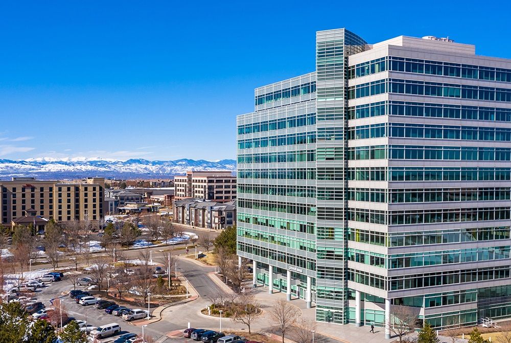 A photo of the Denver Tech Center with the mountains in the background.