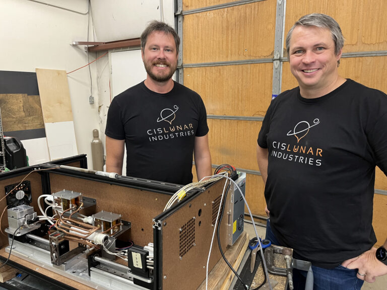Two men in black shirts with electronics equipment