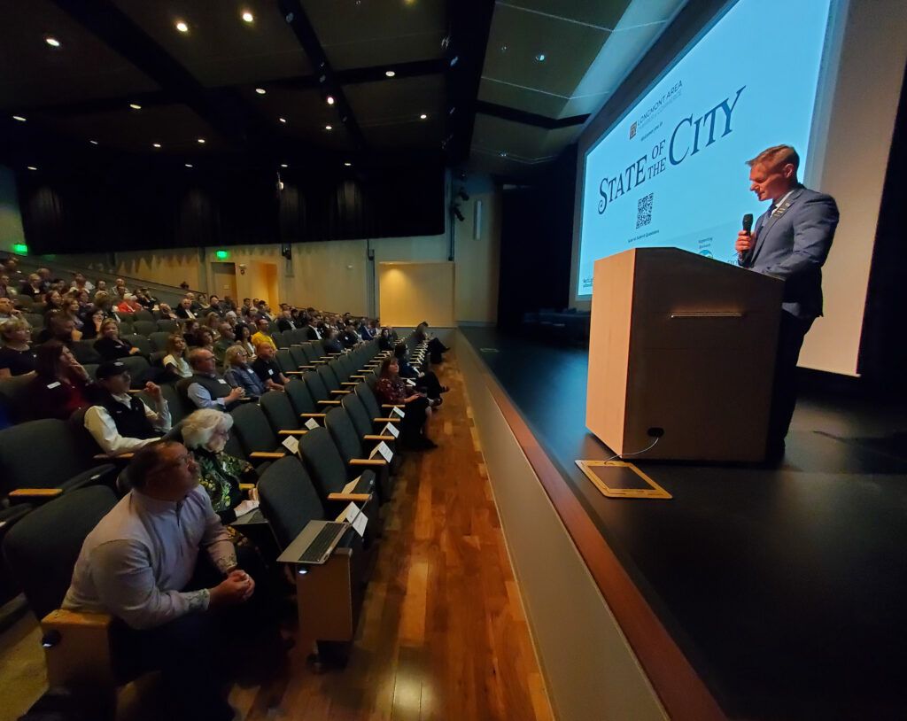 Speaker on stage with people in audience listening