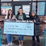 women holding large check