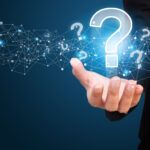 iStock image of woman holding question marks.