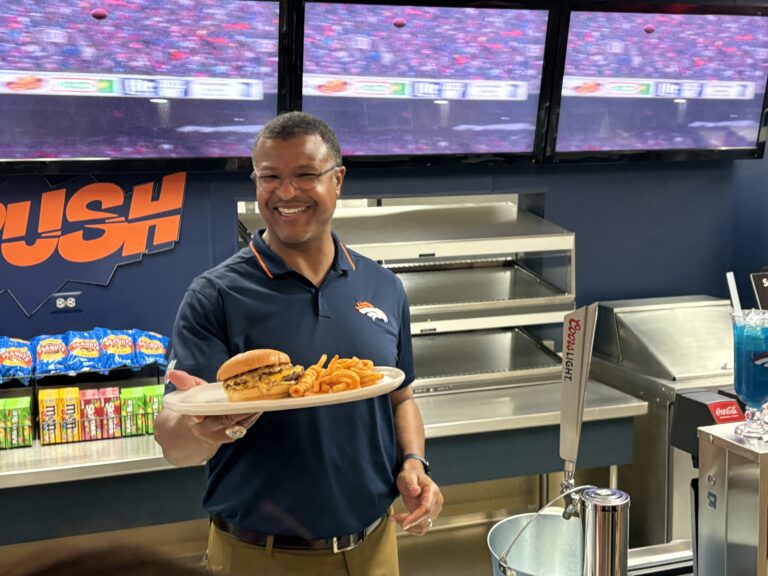 Retired Denver Bronco Steve Atwater showing off at a burger at Empower Field’s new Atwater Grill.