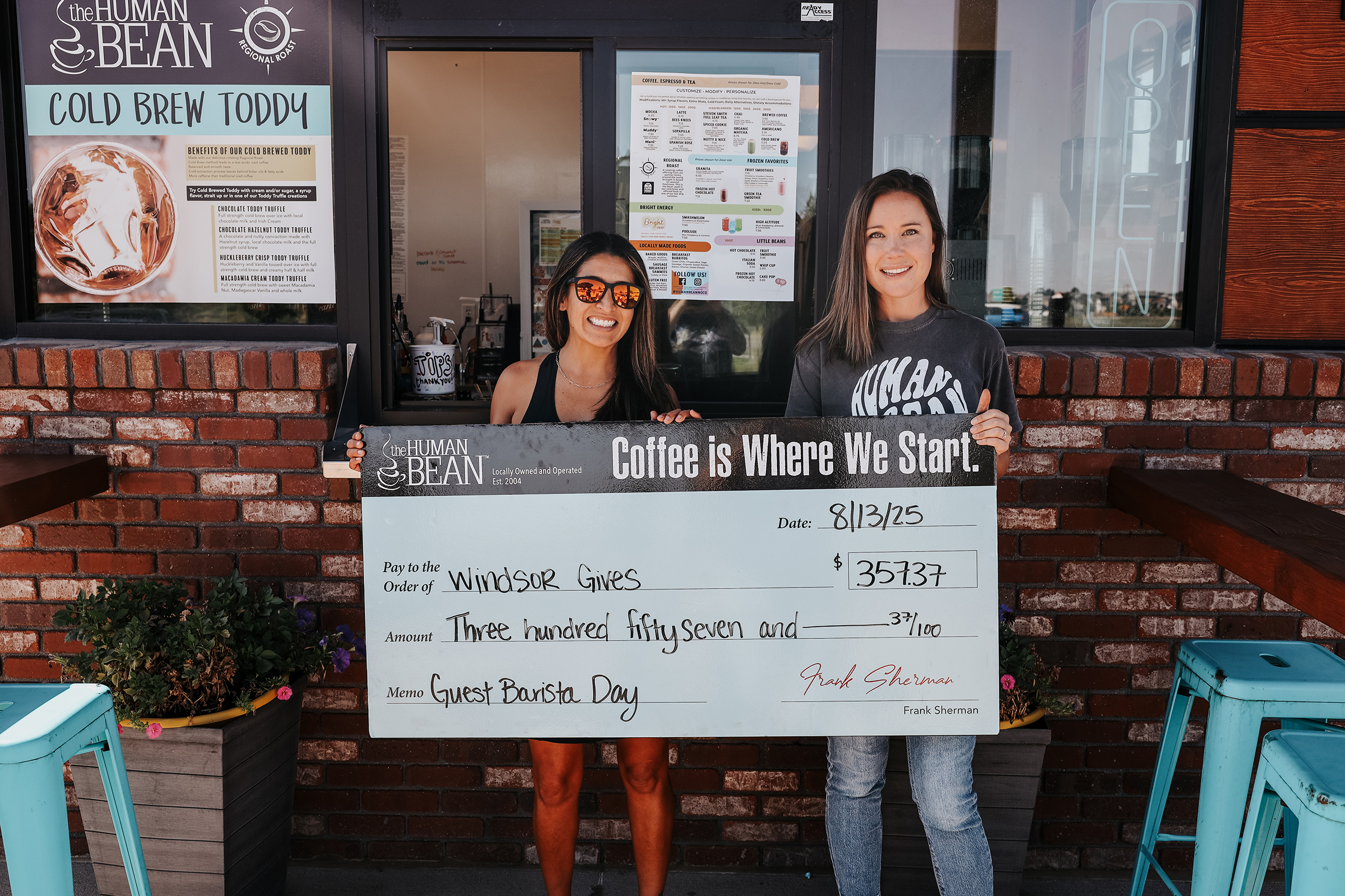 Mandy Mullen, left, president of Windsor Gives, and and Valerie Katalenic, manager, The Human Bean, hold a ceremonial check presented to the nonprofit.