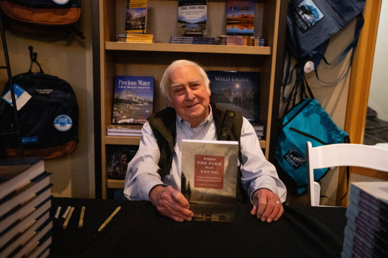 James Pickering signs copies of his new book at a gathering for Rocky Mountain Conservancy members.
