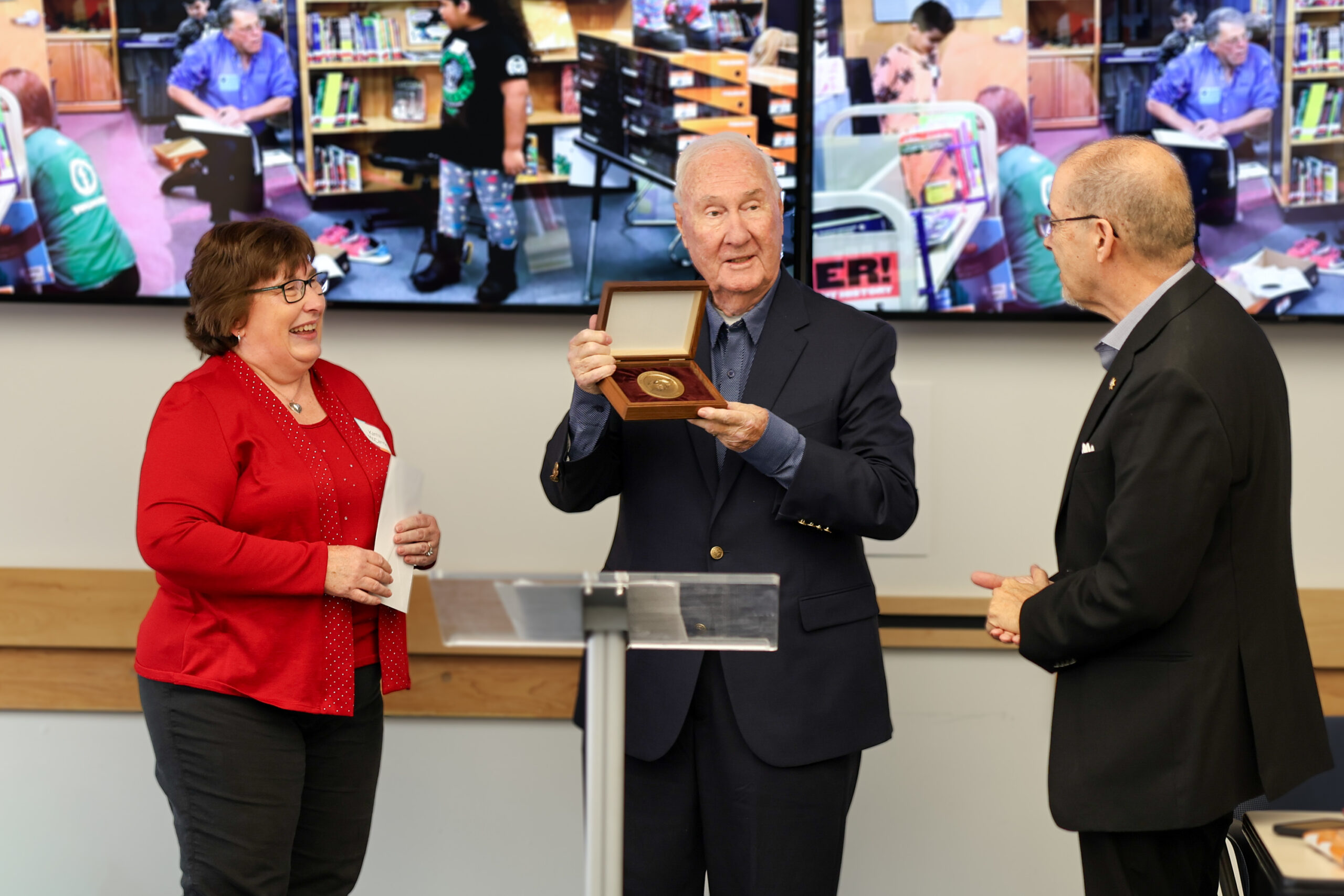 Tire Business senior reporter Kathy McCarron presents Ron Lautzenheiser with the tire industry “Humanitarian of the Year” award on Oct. 24, alongside former Fort Collins mayor Ray Martinez.