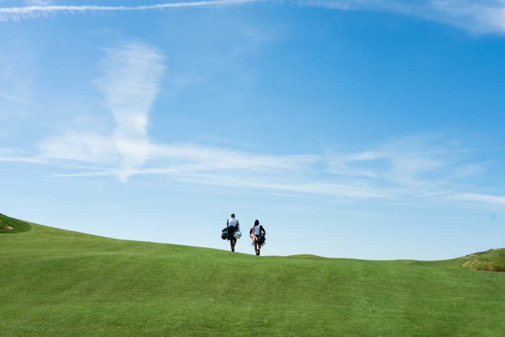 A golfer and caddie walk a Rodeo Dunes fairway.