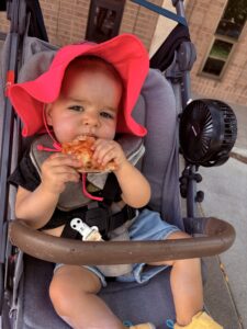 One-year-old Sunny High, daughter of BizWest’s Lucas High, eats a slice of pizza at the Colorado Pizza Festival.